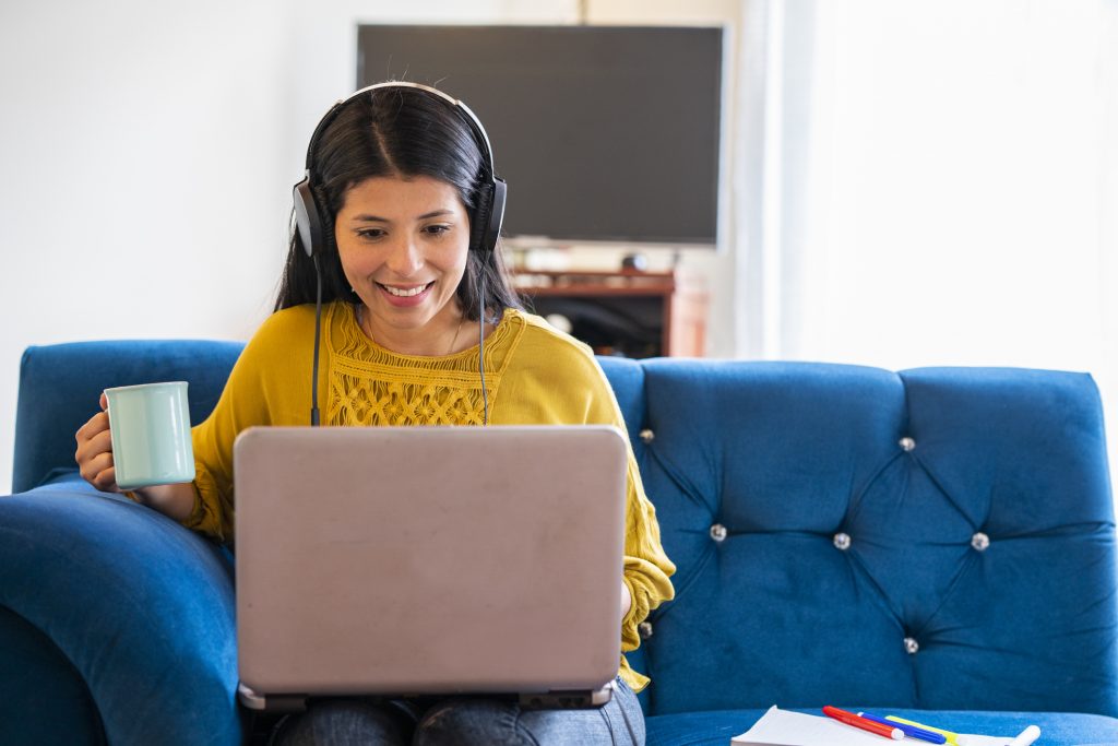 woman drinking coffee looking at laptop