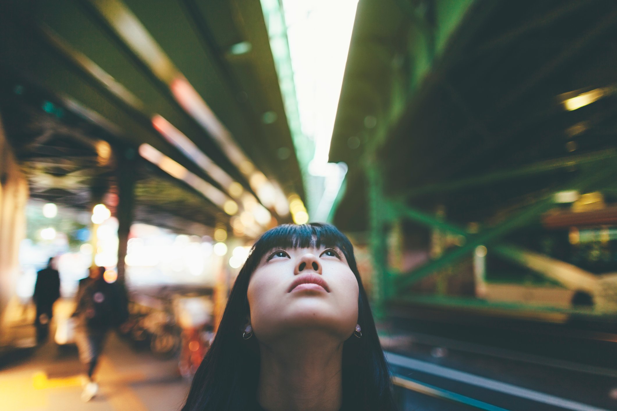 WomanLookingUpAtTwoBridgesInTheCity